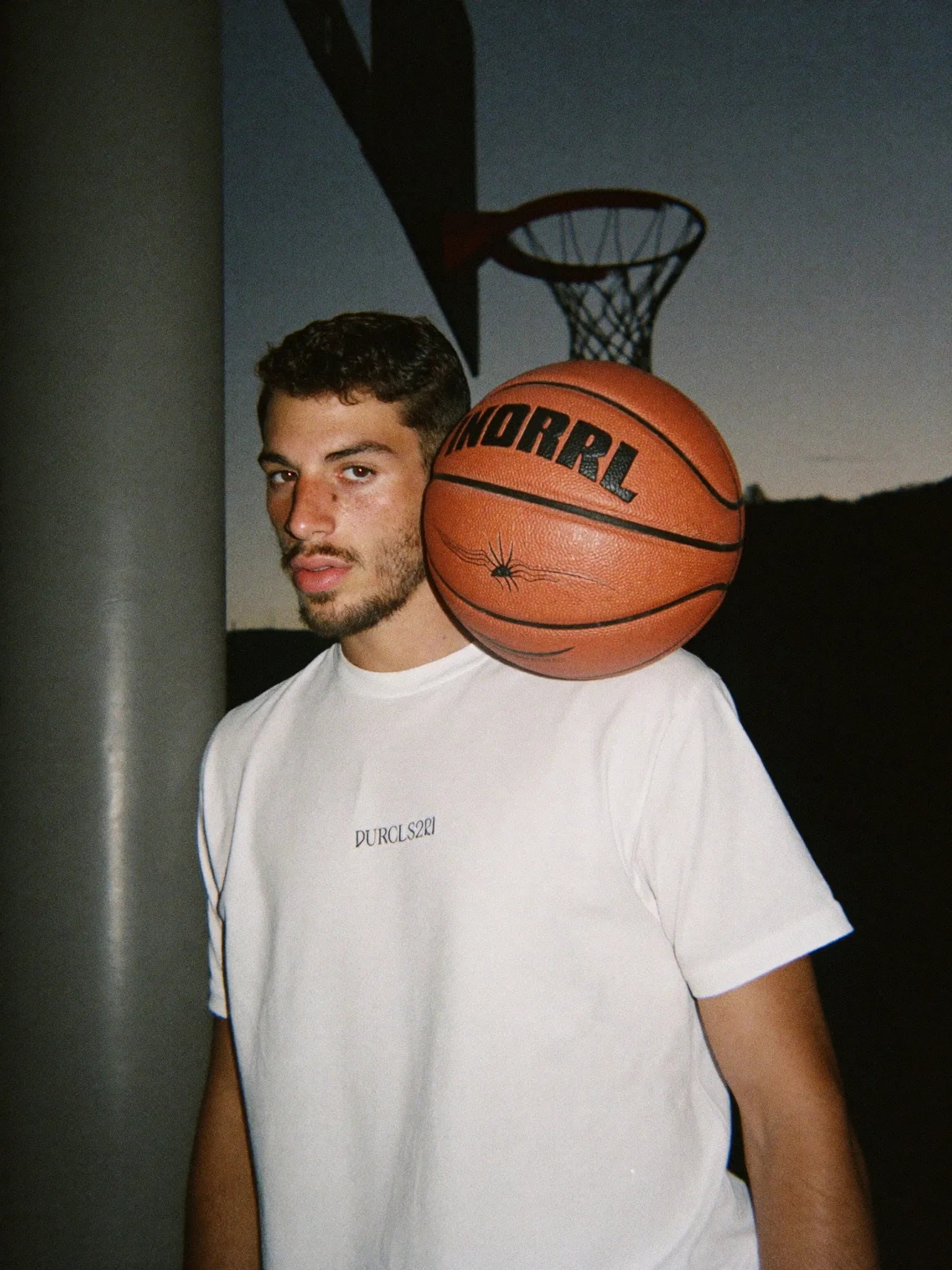 Basketball player holding a ball on an outdoor court